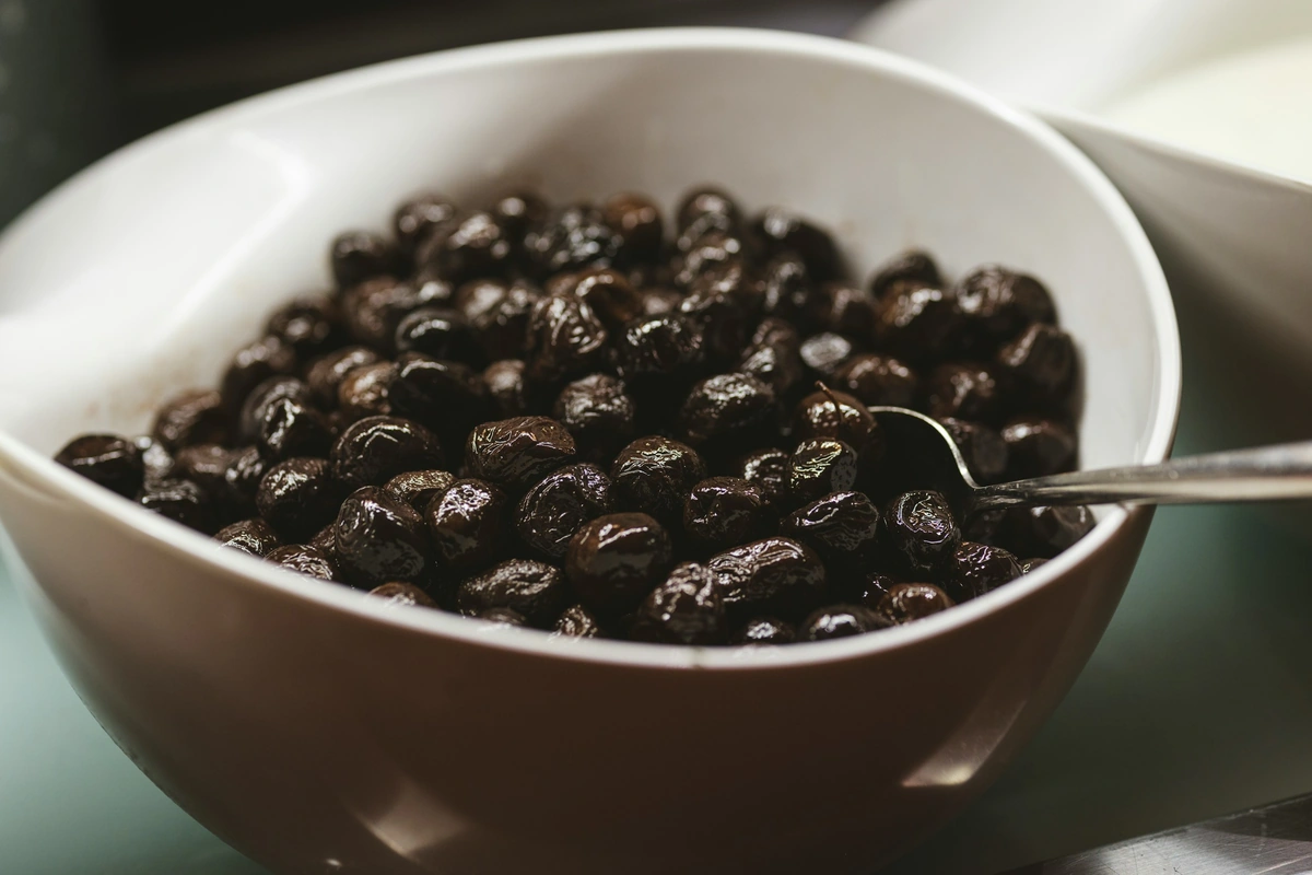 Bowl of black olives with a serving spoon at a buffet