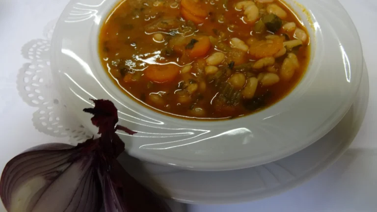 A bowl of fasolada, Greek white bean soup with tomato, carrot and celery