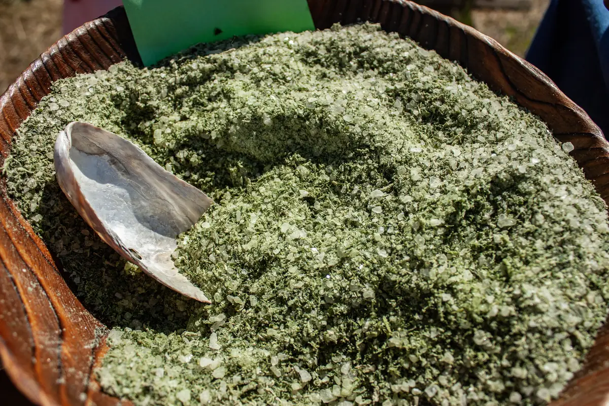 A bowl of green herb salt made with wild garlic, with a small spoon