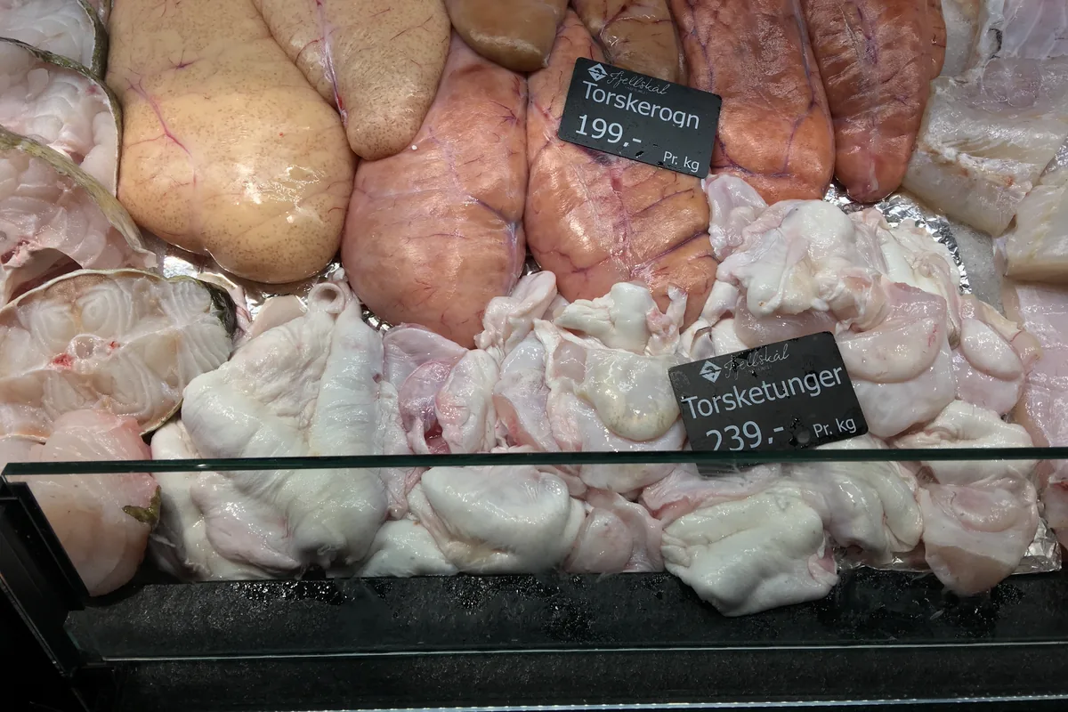 Whole cod roe for sale at a fish market counter