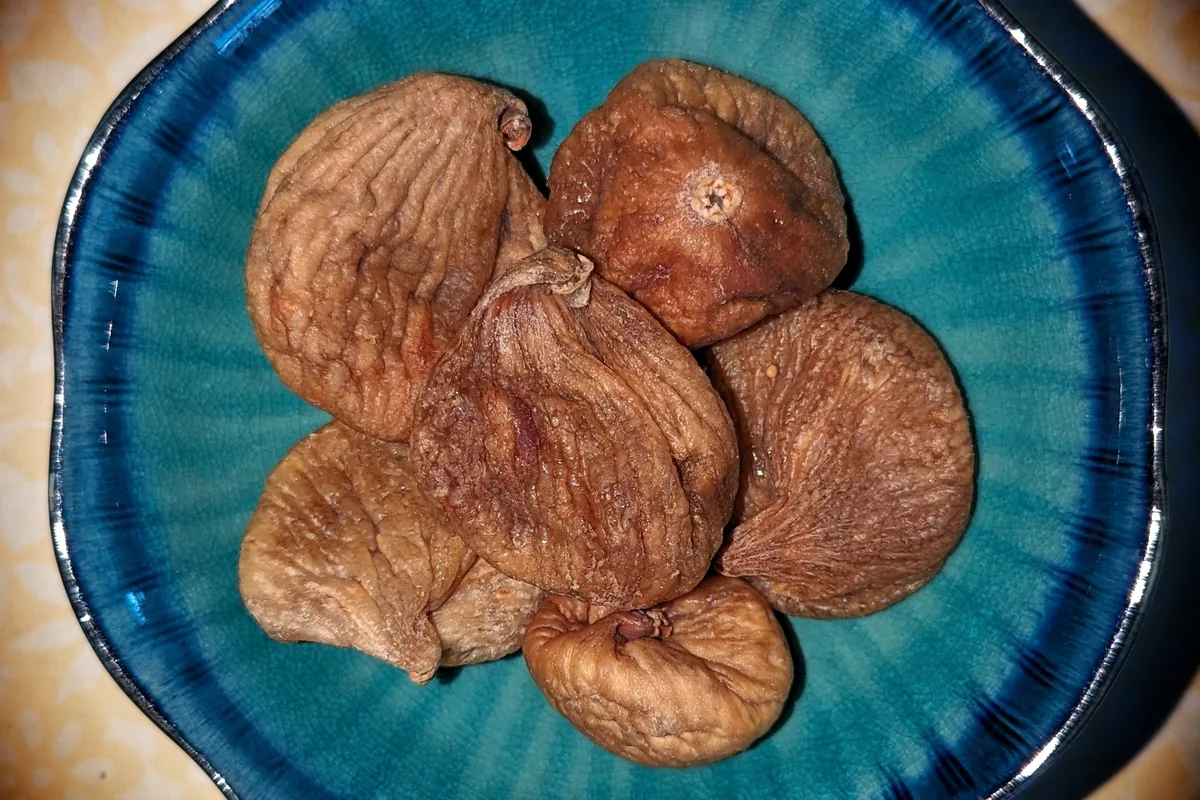 A few dried figs on a blue ceramic plate