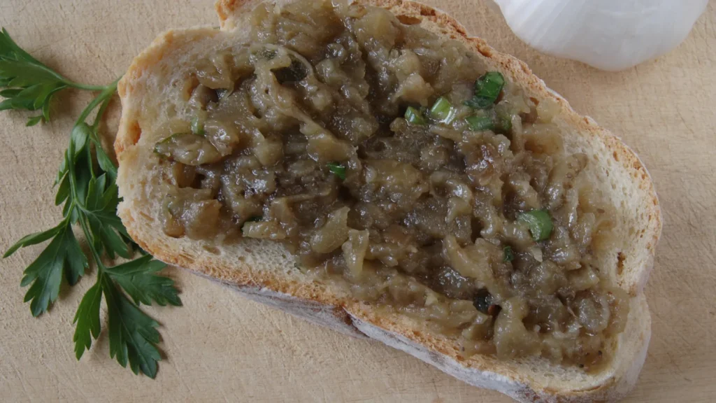 Melitzanosalata, Greek roasted eggplant salad, spread on a slice of bread with parsley