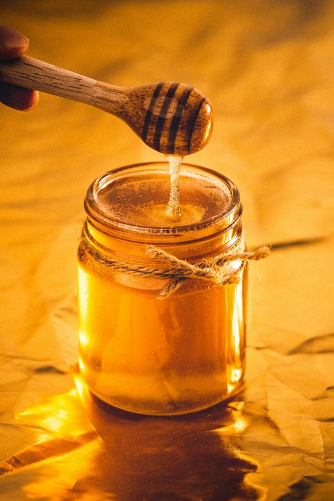 Honey jar with a wooden honey dipper