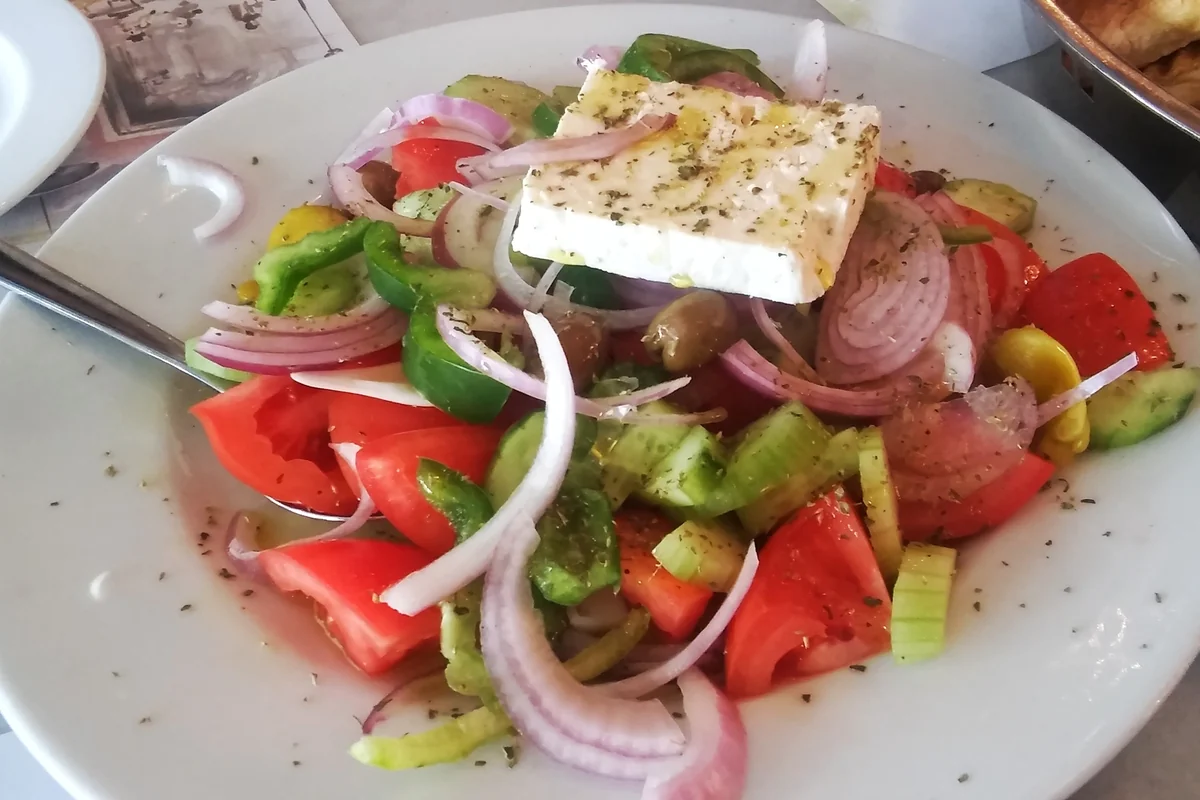 Horiatiki village salad with tomatoes, red onion, cucumber and a block of feta on top