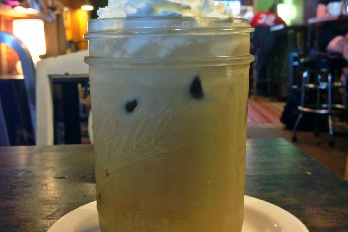 An iced coffee drink in a glass jug, served cold