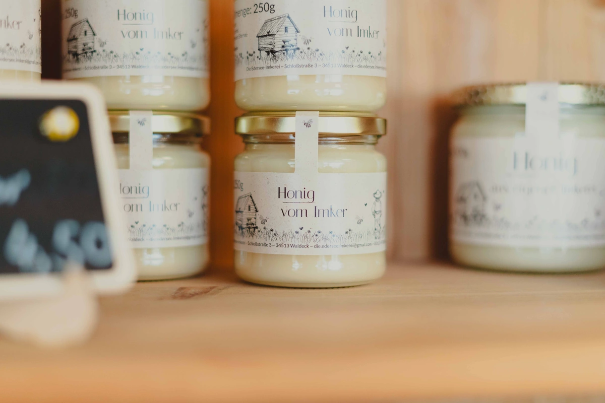 Glass jars of honey with different colours and textures on a shelf