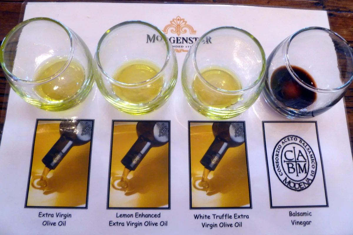 Olive oils poured into tasting glasses on labelled cards for a side-by-side tasting