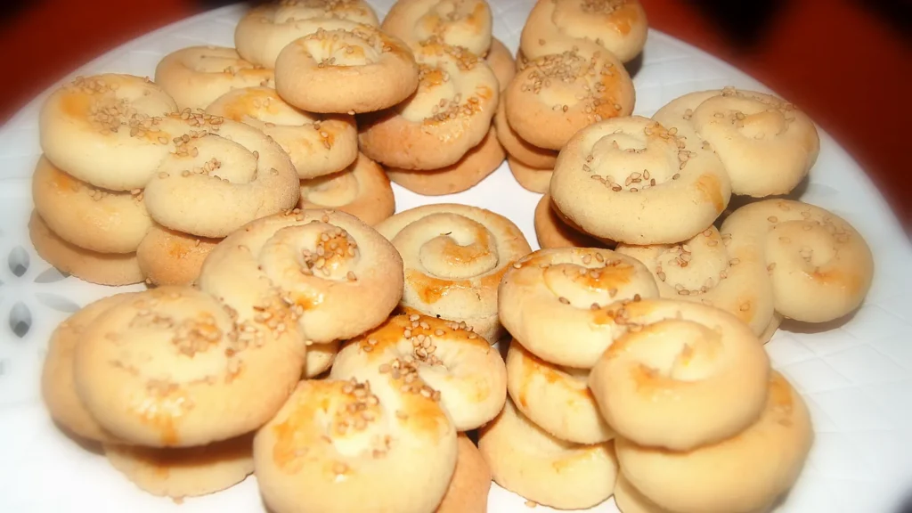 A plate of Greek koulourakia, golden hand-shaped butter cookies