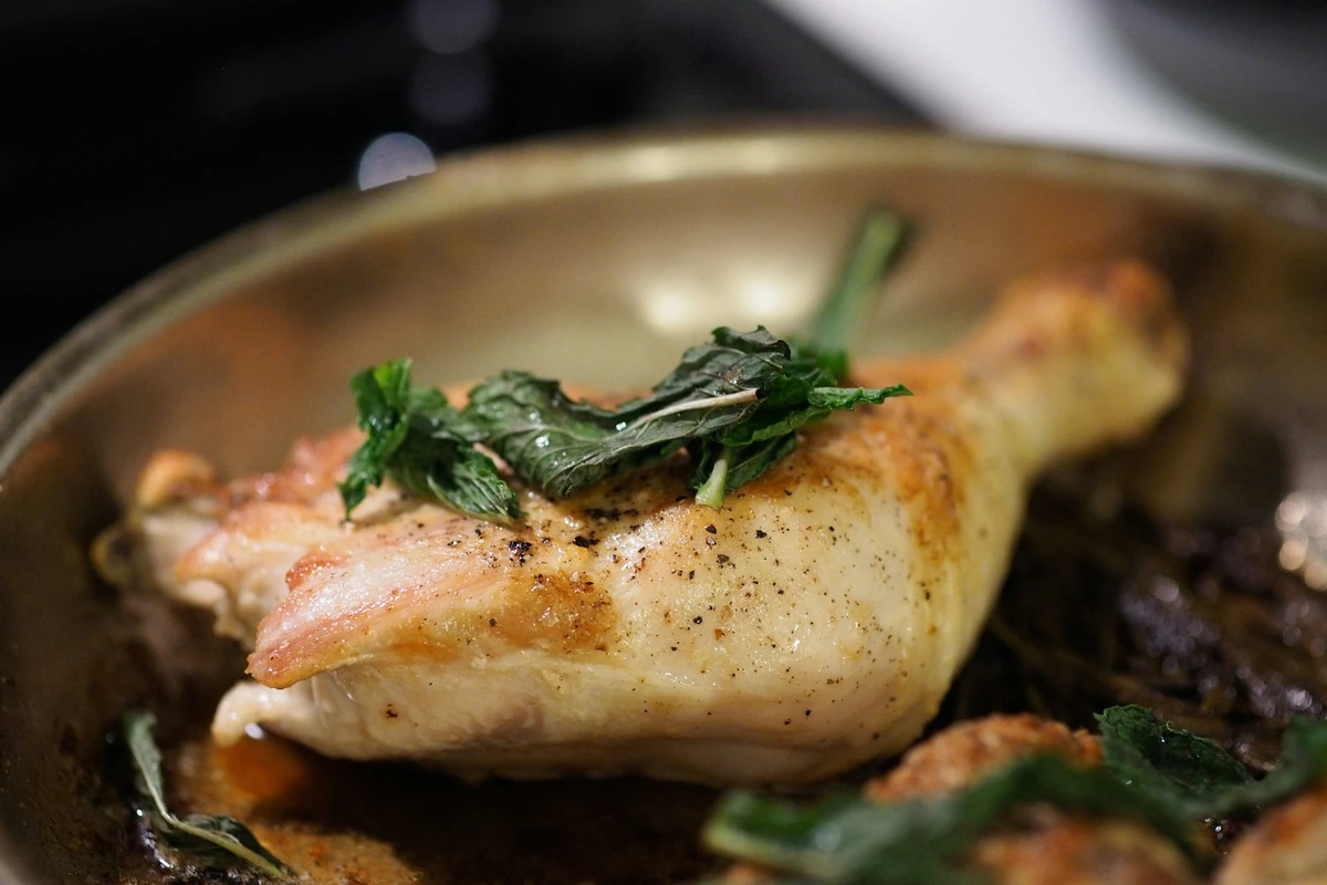Roasted chicken leg with herbs in a pan, a typical dish for Greek seasoning