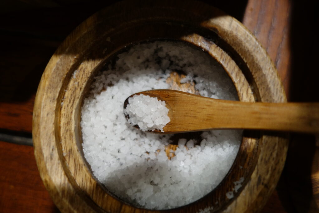 Sea salt in a wooden bowl with a wooden spoon