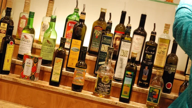 Shelves lined with many different bottles of olive oil to compare