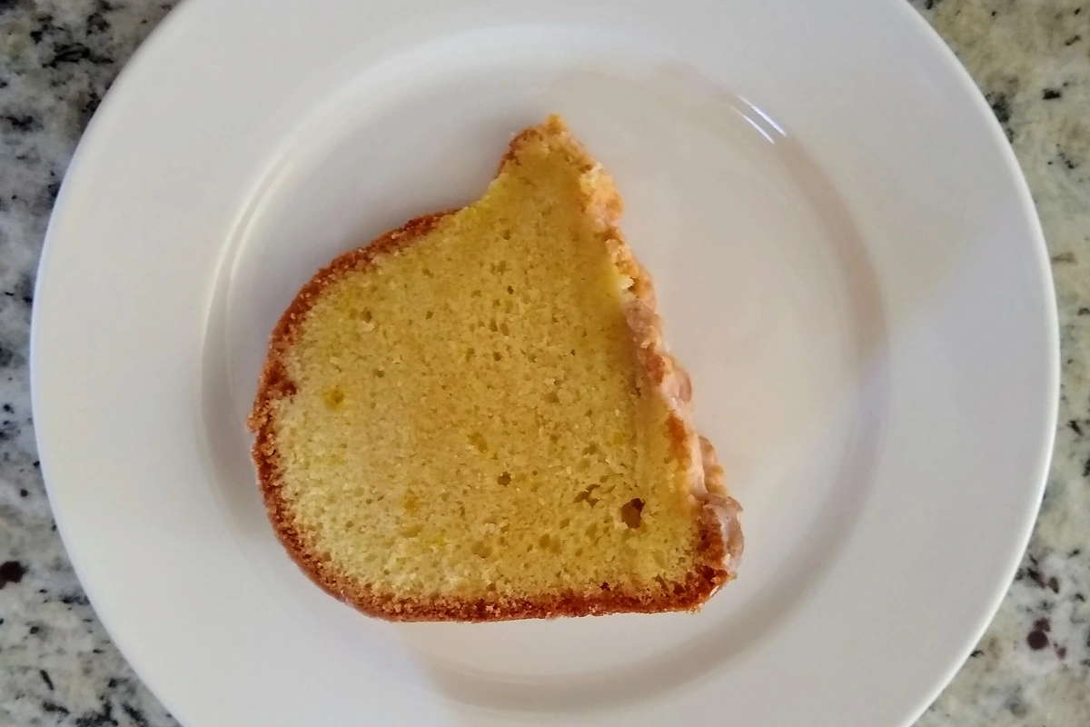 A slice of moist lemon cake on a white plate