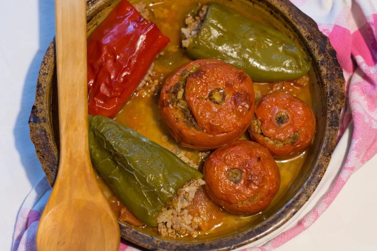 Stuffed peppers and tomatoes filled with rice and minced meat in a baking pan