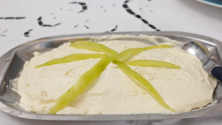 A platter of tirokafteri, Greek spicy whipped feta dip, topped with strips of green chili pepper