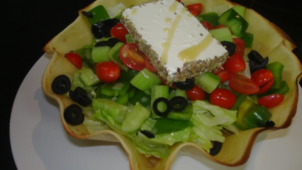 Traditional Greek salad (horiatiki) with tomato, cucumber, green pepper, onion, black olives and a slab of feta