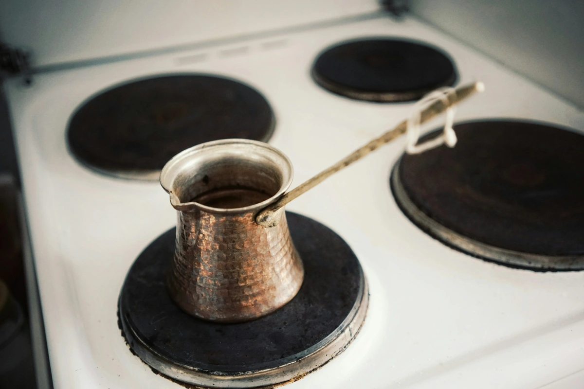 Small briki coffee pot heating on an electric stove