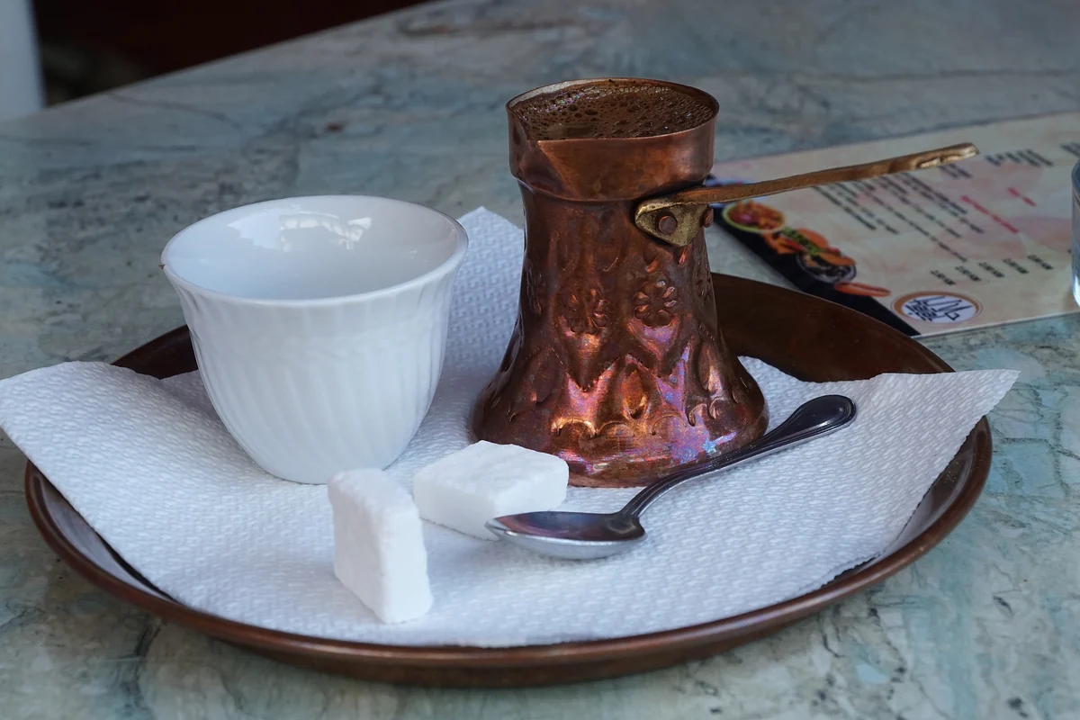 Copper coffee pot and small cup on a tray, as served in Bosnia