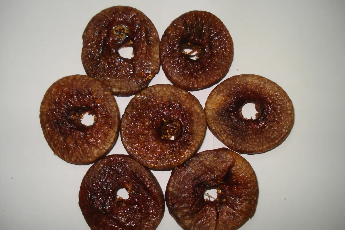Flattened dried figs arranged on a white background