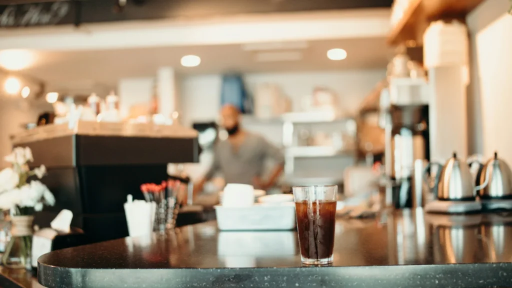 Busy cafe counter with drinks and staff, a typical buyer of Greek food wholesale