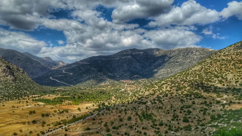 Green mountain slopes under clouds, the kind of wild habitat where Greek mountain tea grows