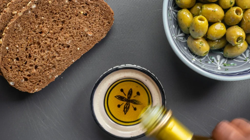 Bread, green olives and a dish of olive oil, simple Greek olive oil uses at the table