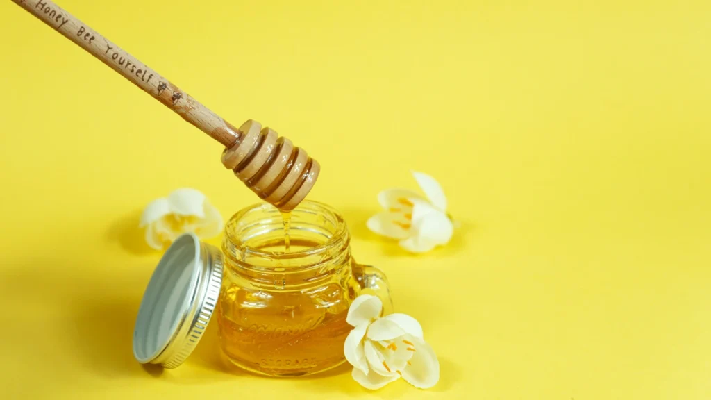 Jar of golden honey with a wooden dipper, illustrating Greek thyme honey