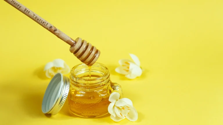 Jar of golden honey with a wooden dipper, illustrating Greek thyme honey