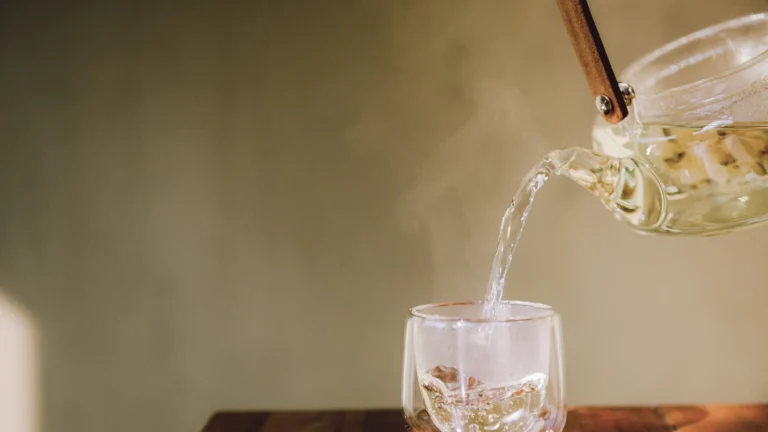 Tea pouring from a glass teapot into a glass cup, showing how to brew Greek mountain tea