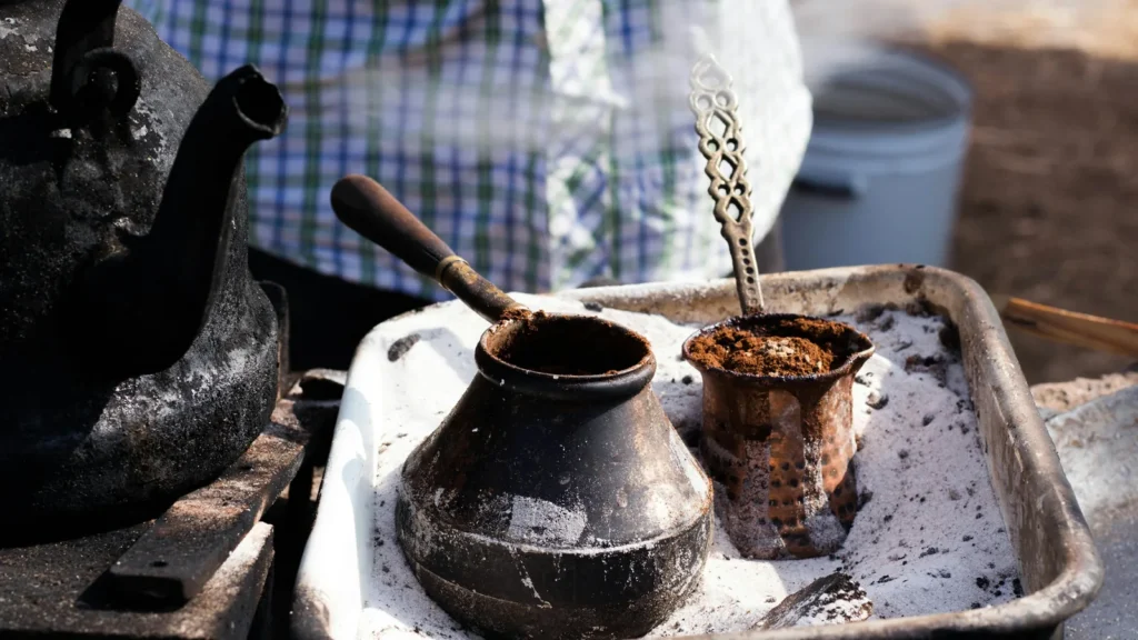 Coffee pots brewing on a hot tray, a traditional way of how to make Greek coffee