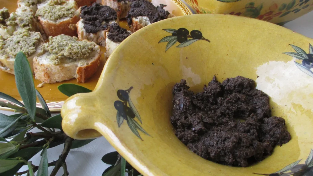 Bowl of black olive tapenade with toast, the result of a Kalamata olive tapenade recipe