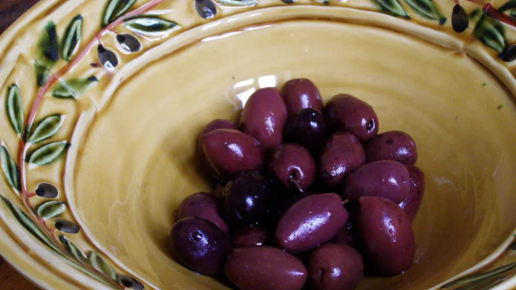 Glossy purple Kalamata olives in a ceramic bowl, for comparing Kalamata olives vs black olives