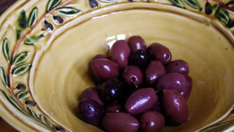 Glossy purple Kalamata olives in a ceramic bowl, for comparing Kalamata olives vs black olives