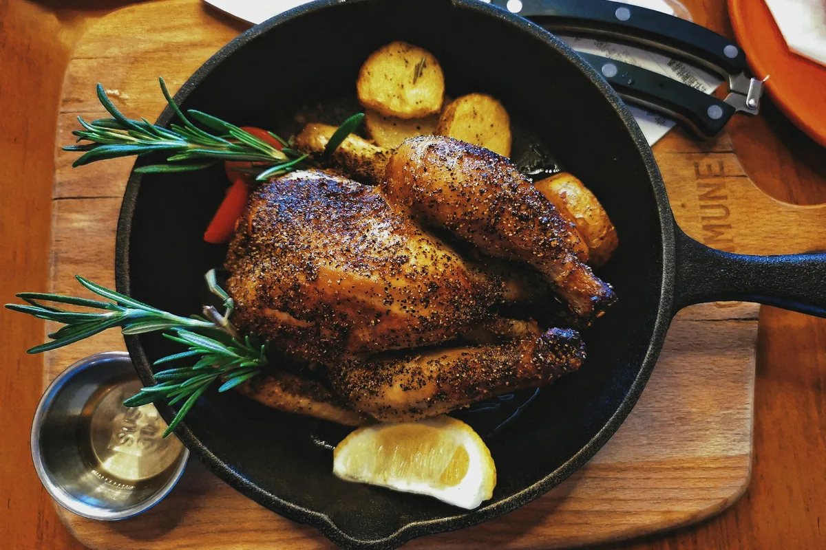 Roast chicken with herbs and lemon in a cast-iron pan, a classic use for Greek thyme