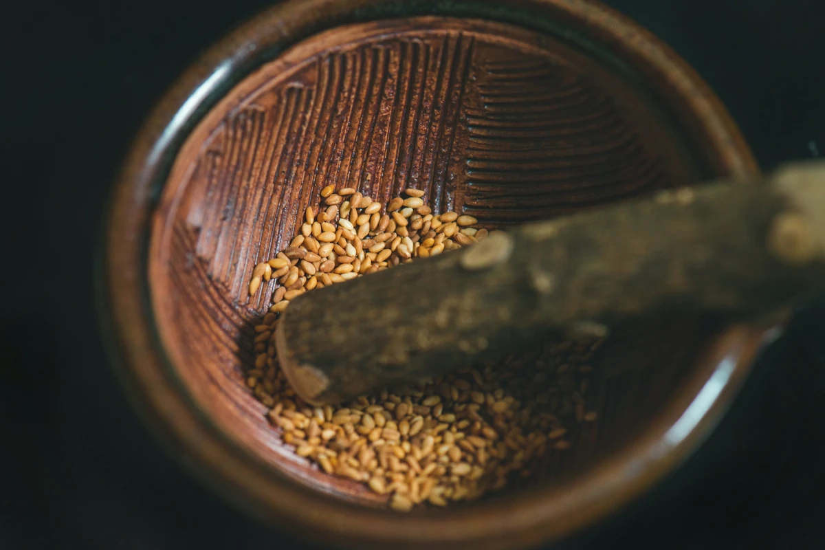 Roasted sesame seeds in a wooden grinding bowl